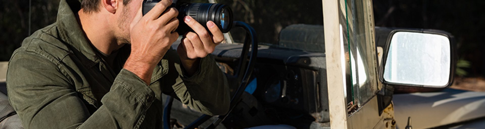 Man photographing while sitting in off road vehicle