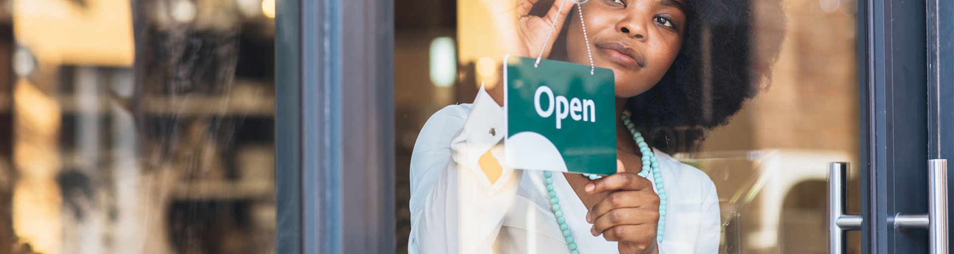 lady-putting-open-sign-on-the-door-to-her-business